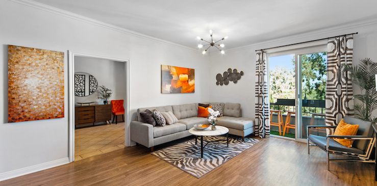 Modern living room with gray sofa and warm orange accents