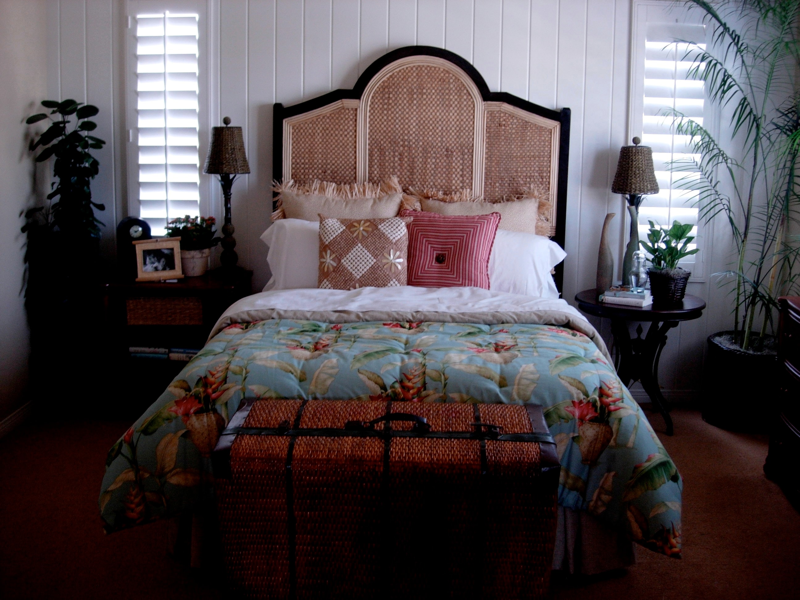 Bedroom with woven rattan headboard, botanical bedding, and natural textures