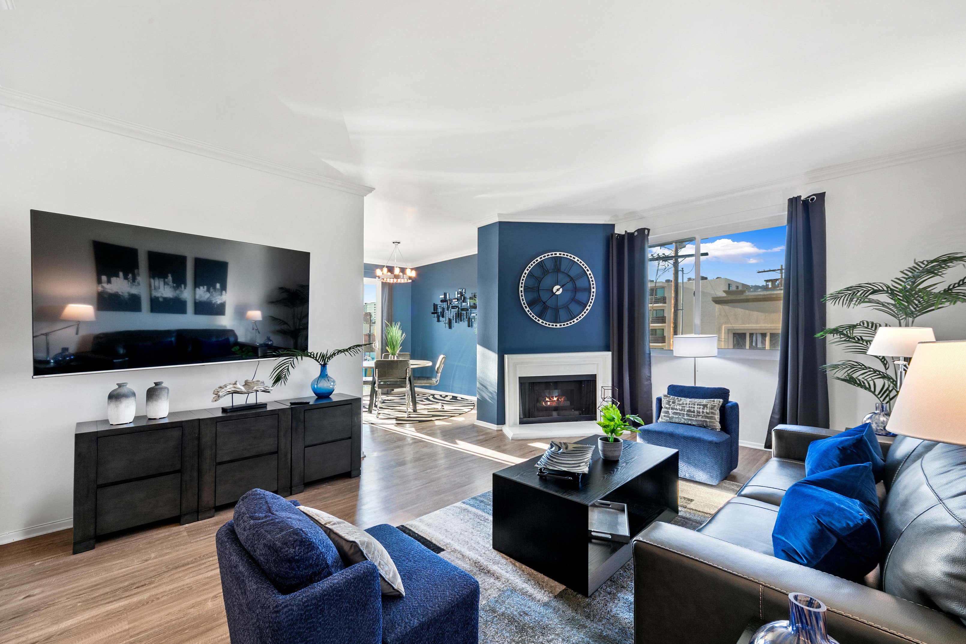 Cobalt living room with fireplace, television, and modern furnishings