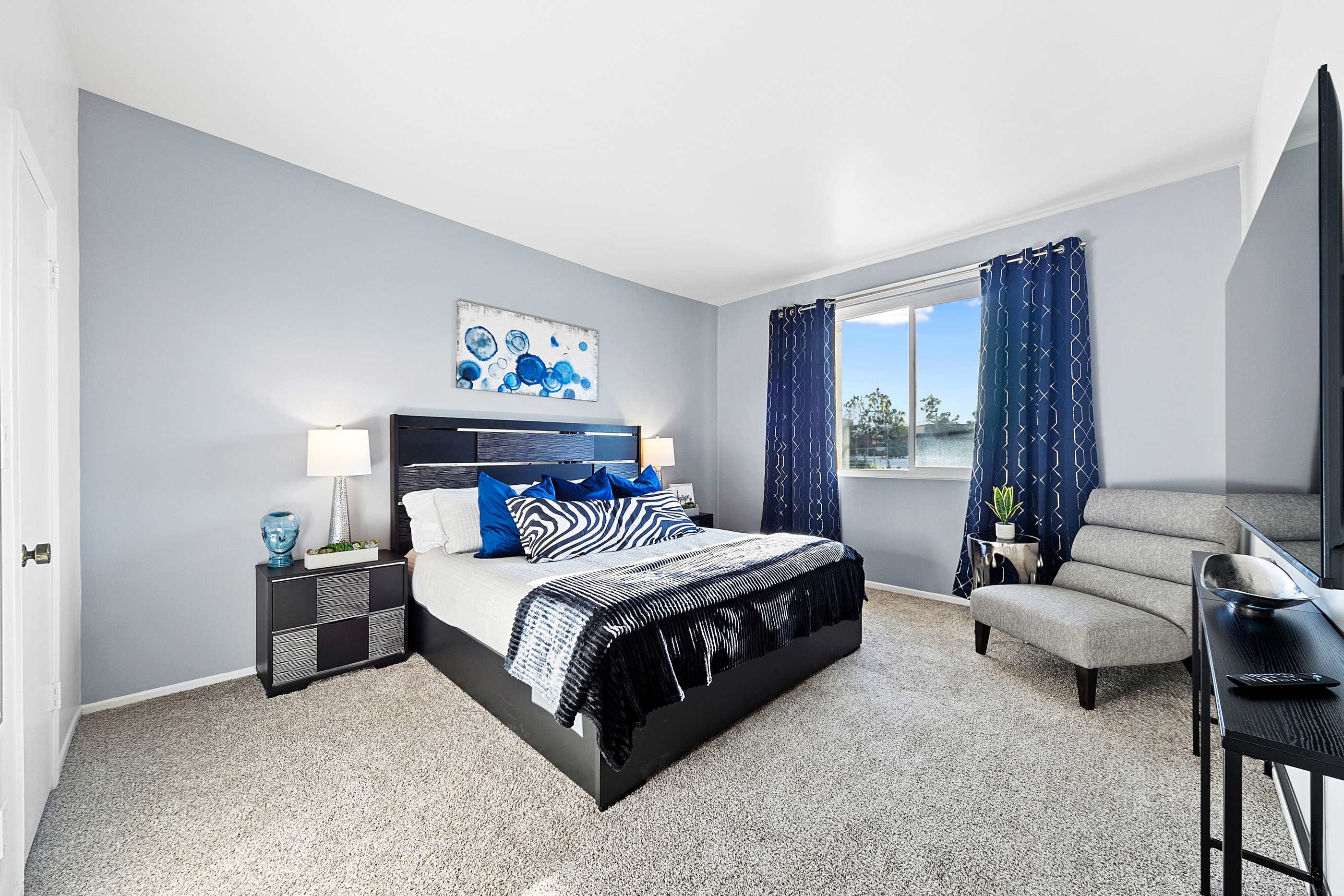Primary bedroom with cobalt accents and a waterfront view