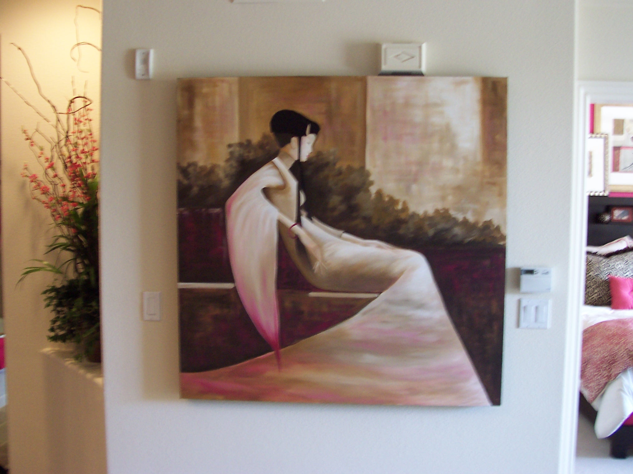 Entry wall with Asian-inspired artwork, flowering branches, and a glimpse of the magenta bedroom