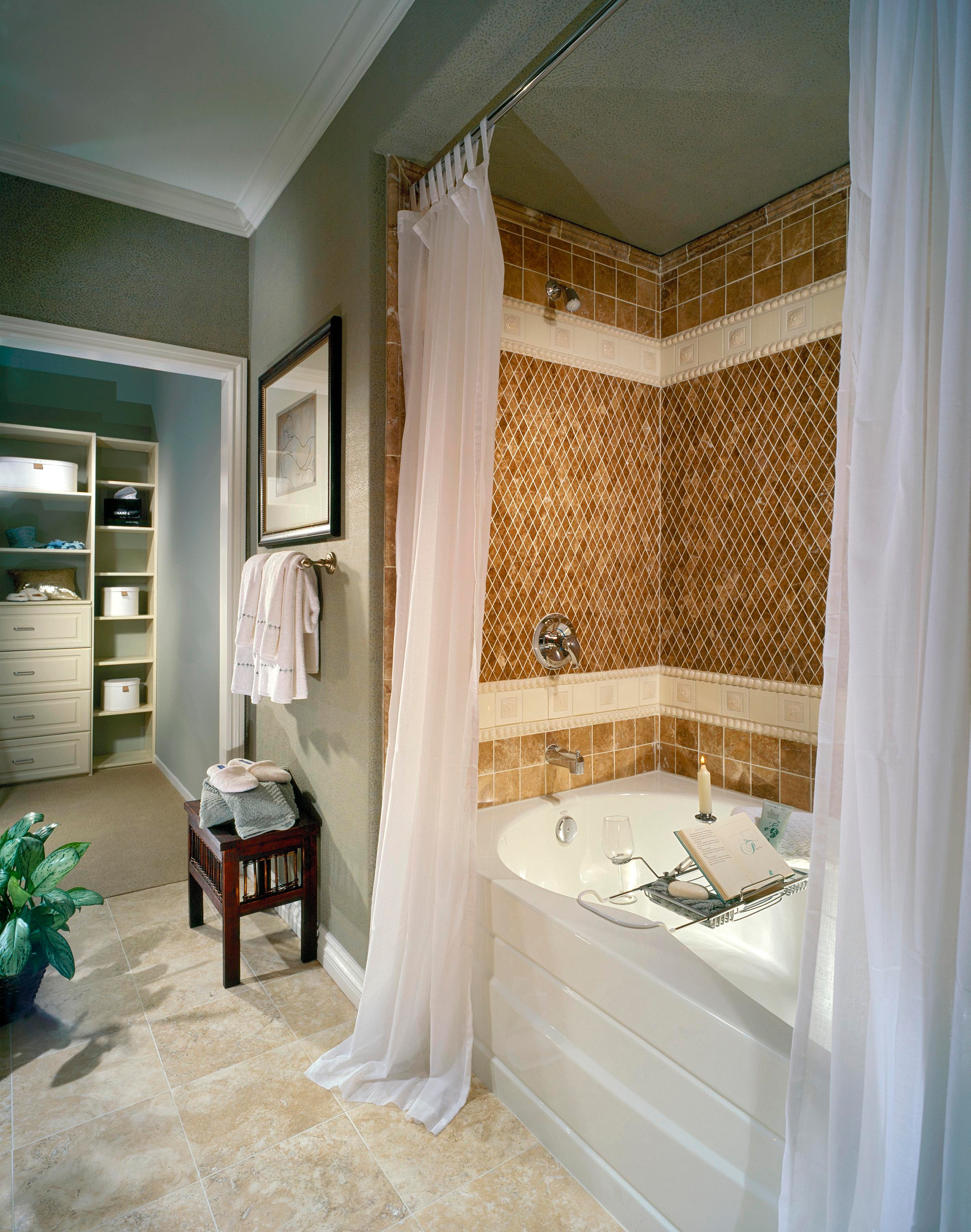 Bathroom with tiled soaking tub, patterned shower surround, and soft green walls