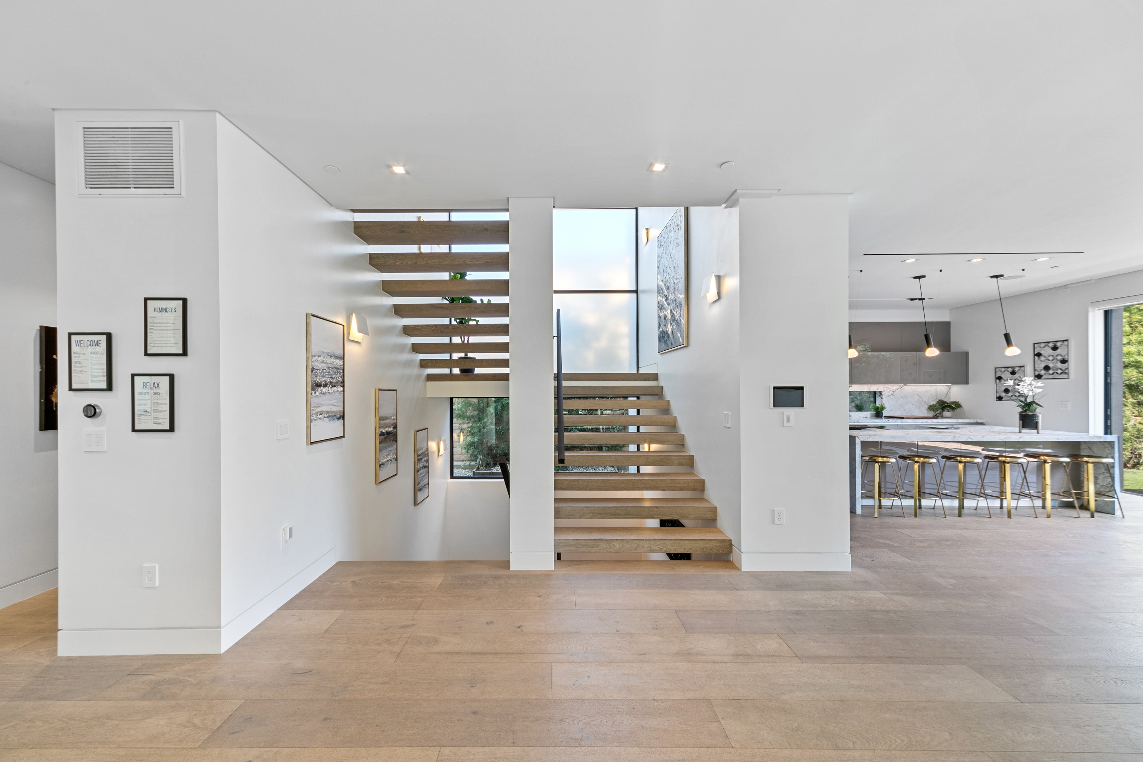Floating staircase beside a bright contemporary kitchen