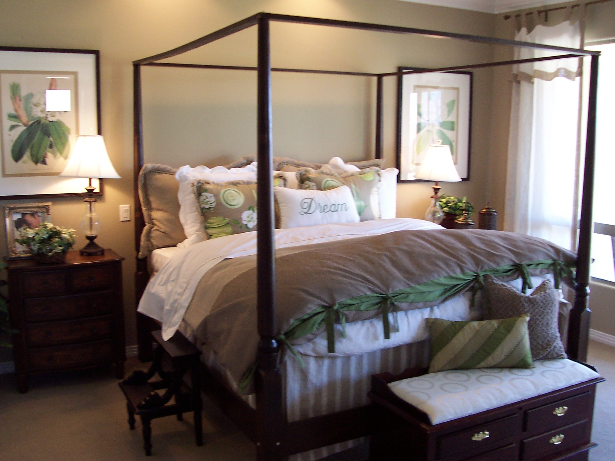 Four-poster bedroom with botanical artwork and layered bedding
